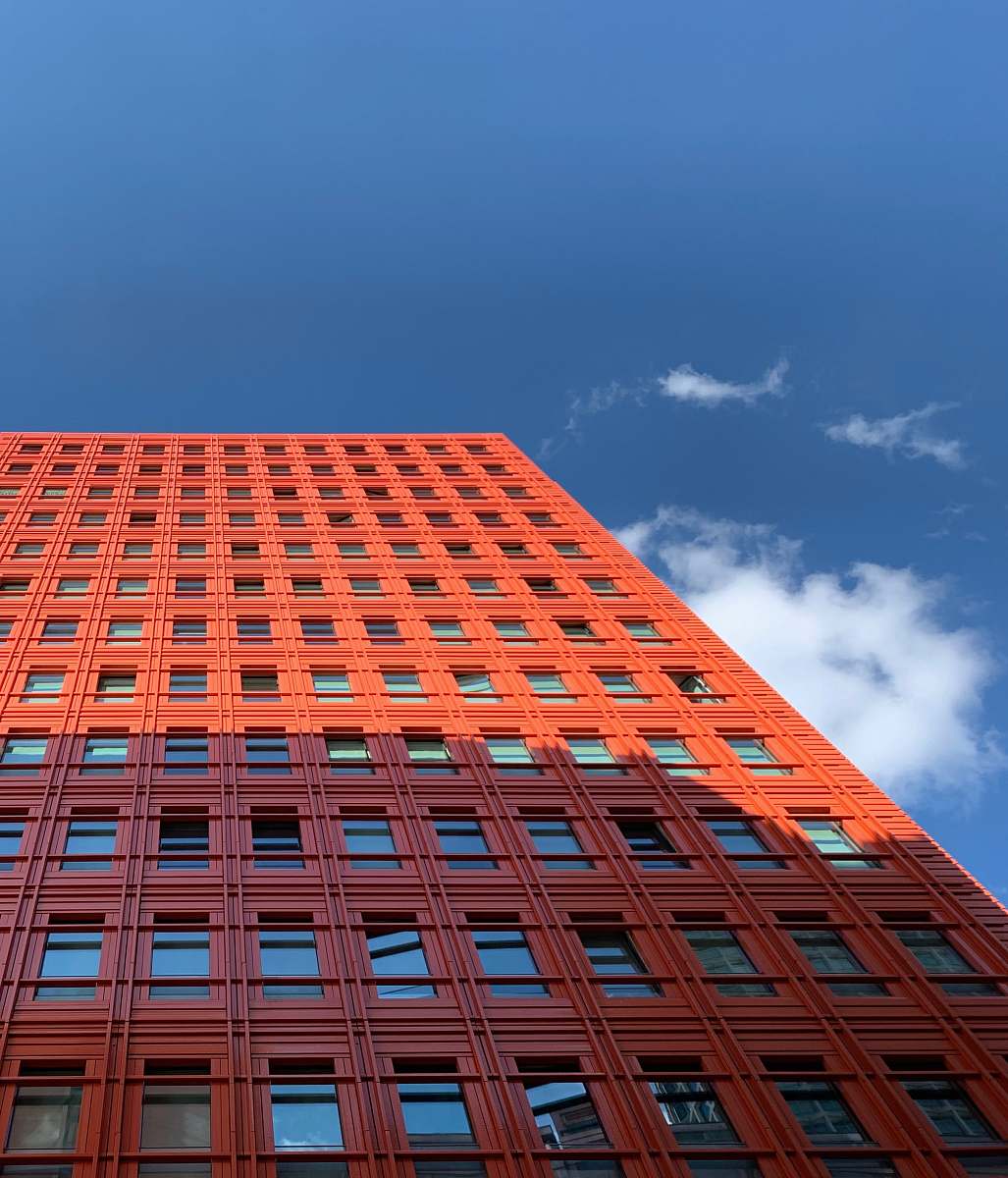 office building low-angle photography of red building under blue sky city